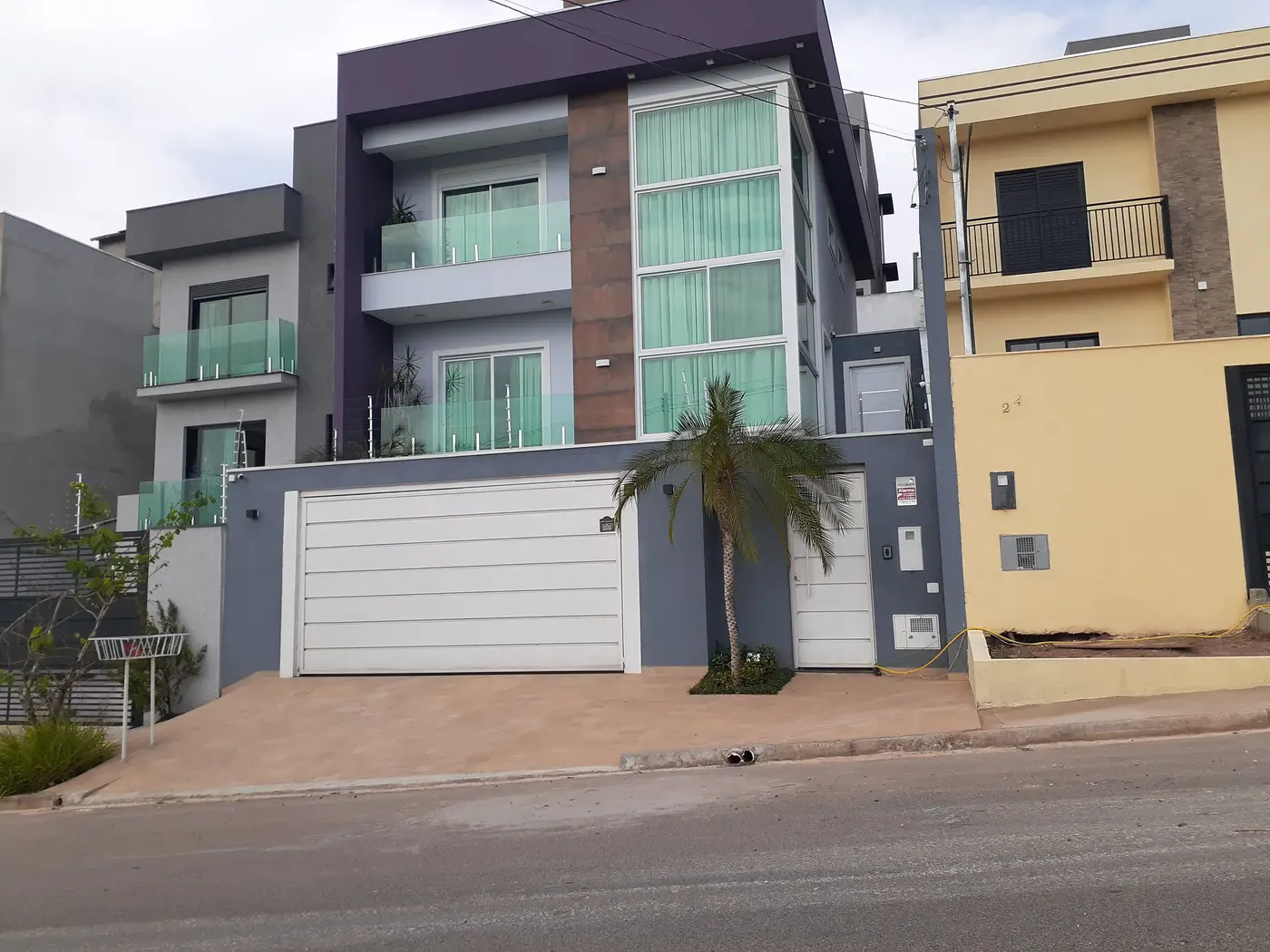 Fachada residencial com portão de garagem basculante em alumínio executado pela Super Esquadrias